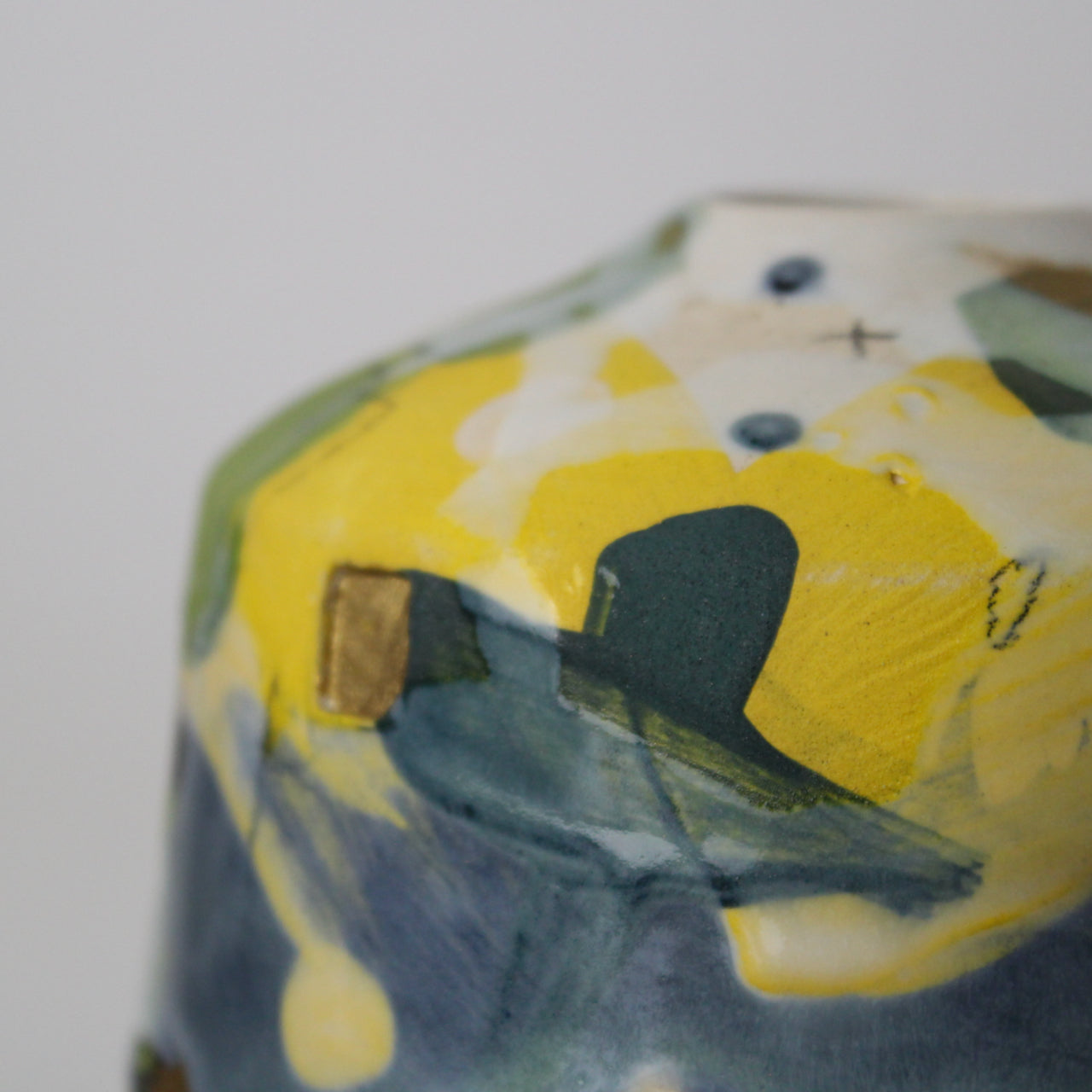 close up of glaze on small textured ceramic  bottle in yellow, grey and green by UK ceramicist Dawn Hajittofi.