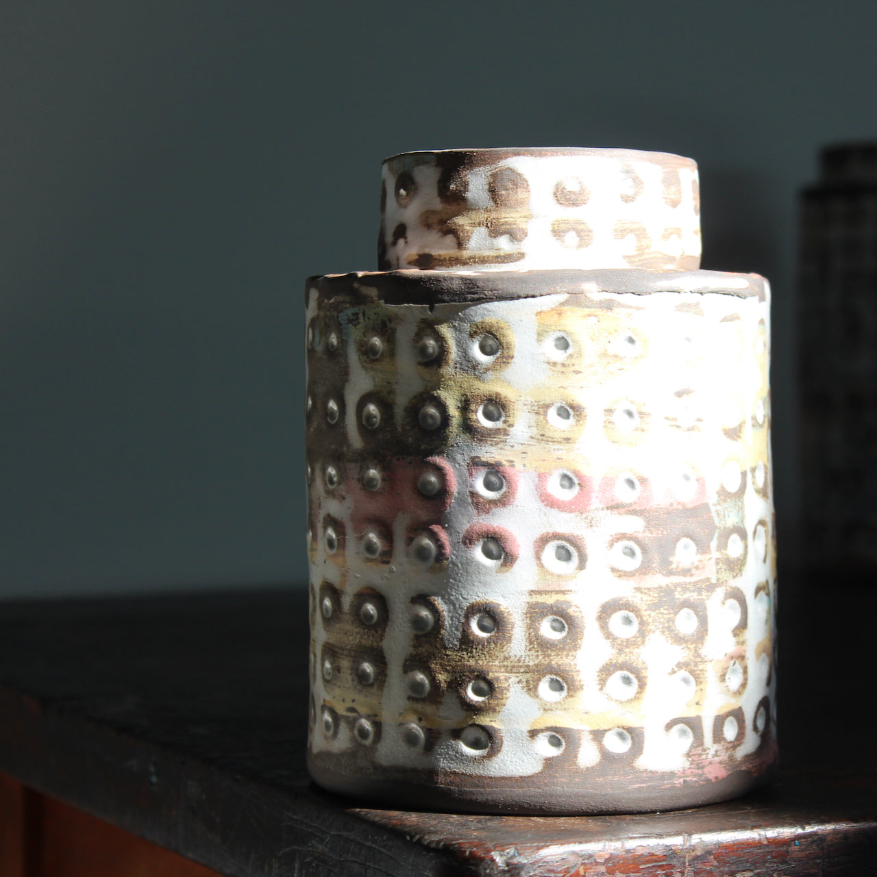 a  textured ceramic vessel in pinks, blues and mustard by UK ceramicist Elly Wall.