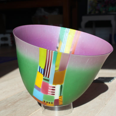 Ruth Shelley large titling glass bowl in greens and  purple with central detail in  yellow, pale blue and pinks