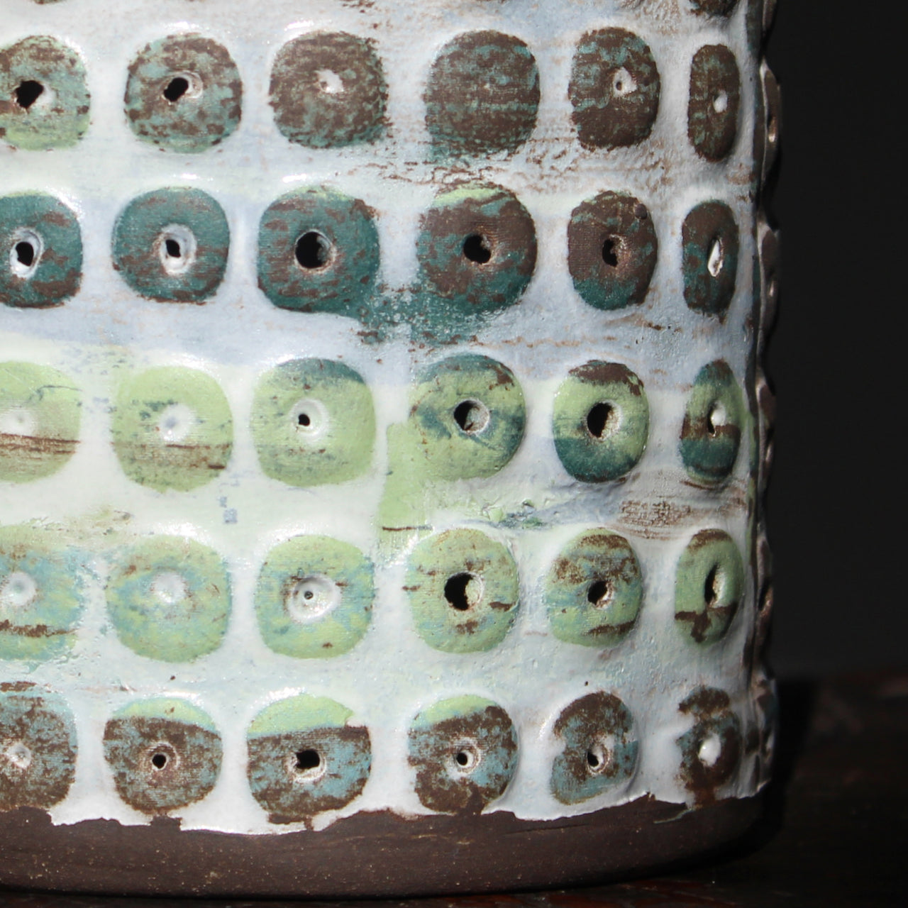 close up of a  textured ceramic vessel in brown, blues and green by UK ceramicist Elly Wall