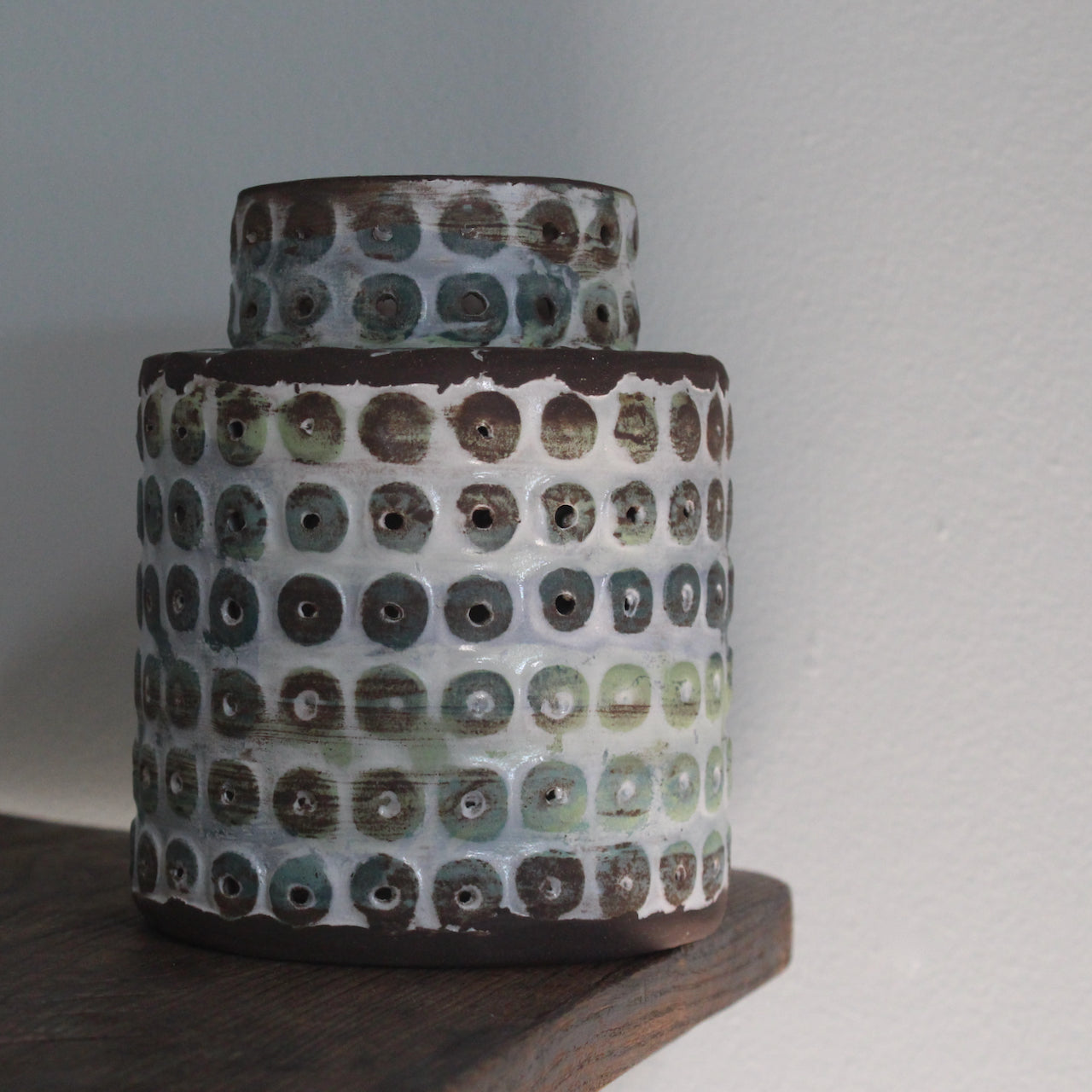 a  textured ceramic vessel in brown, blues and green by UK ceramicist Elly Wall.