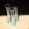 trio of tall and narrow clear glass vessels with turquoise and white details by Helen Eastham glass artist.