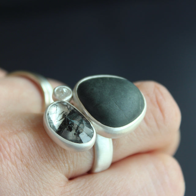 Beach pebble, tourmalinated quartz and white diamond ring by Carin Lindberg on finger
