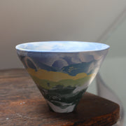 a small ceramic bowl in blue, yellow and green and black  by ceramic artist Judy Mckenzie.