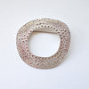 textured silver round brooch with a hollow middle by jeweller Ann Bruford