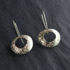 silver drop earrings by UK jewellery designer Ann Bruford with a hollow centre and a textured surface pattern.