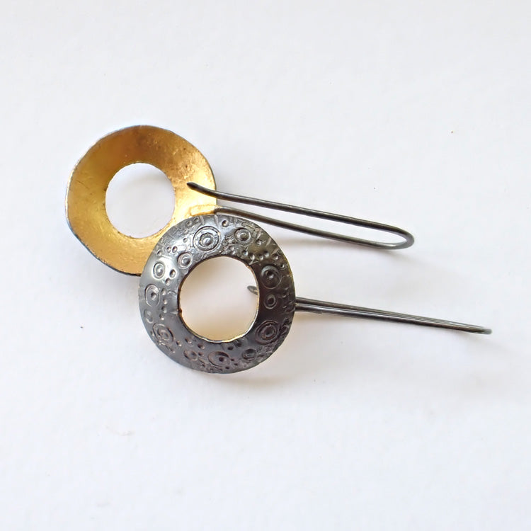 circular drop earrings with gold on the inside and a textured dark finish on the outside they are by Ann Bruford, Devon jeweller