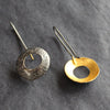 a pair of circular drop earrings with gold on the inside and a textured dark finish on the outside they are by Ann Bruford, Devon jeweller 