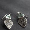 Textured silver with aquamarine stone drop earrings on a dark grey background 