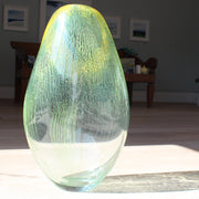 a green and yellow glass vessel by glass artist Benjamin Lintell.