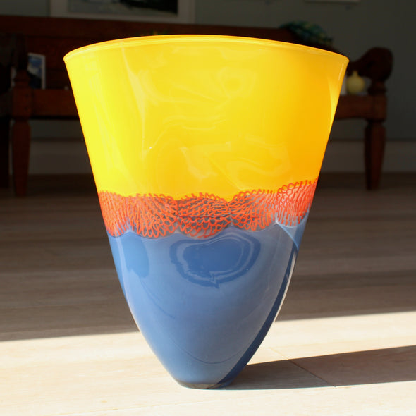 glass vessel by Benjamin Lintell with a blue base and orange top divided by a red detail 