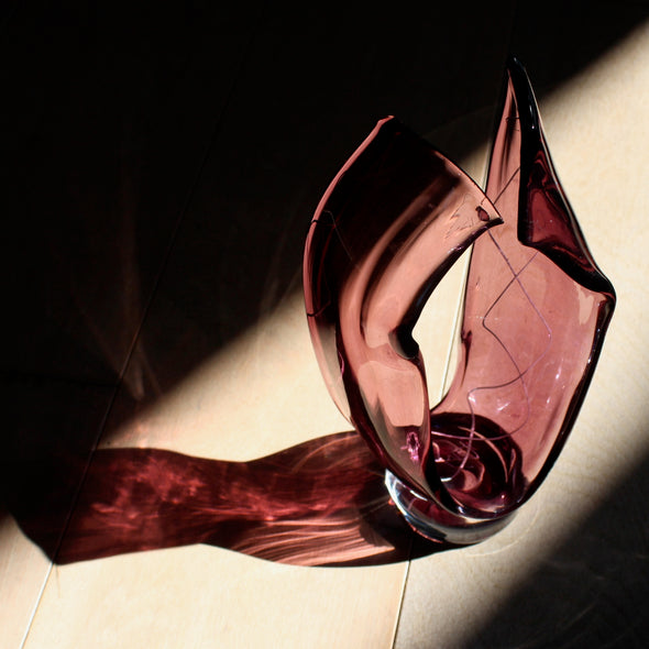 a small deep pink glass sculpture with white decoration by UK glass artist Benjamin Lintell