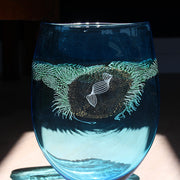 a large blue glass vessel with centre detail by Benjamin Lintell  photographed in sunlight.