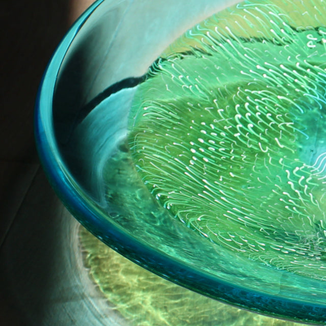 Close up detail of a blue and green glass bowl by Benjamin Lintell  photographed in sunlight