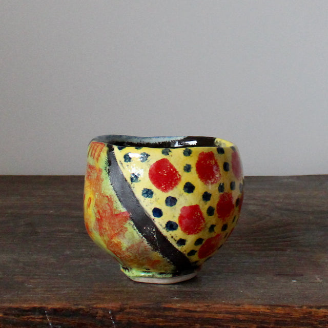 brightly coloured small ceramic bowl in yellow and red by UK potter John Pollex