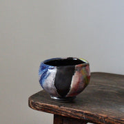 a ceramic tea bowl in blues, pinks and reds by UK potter John Pollex.