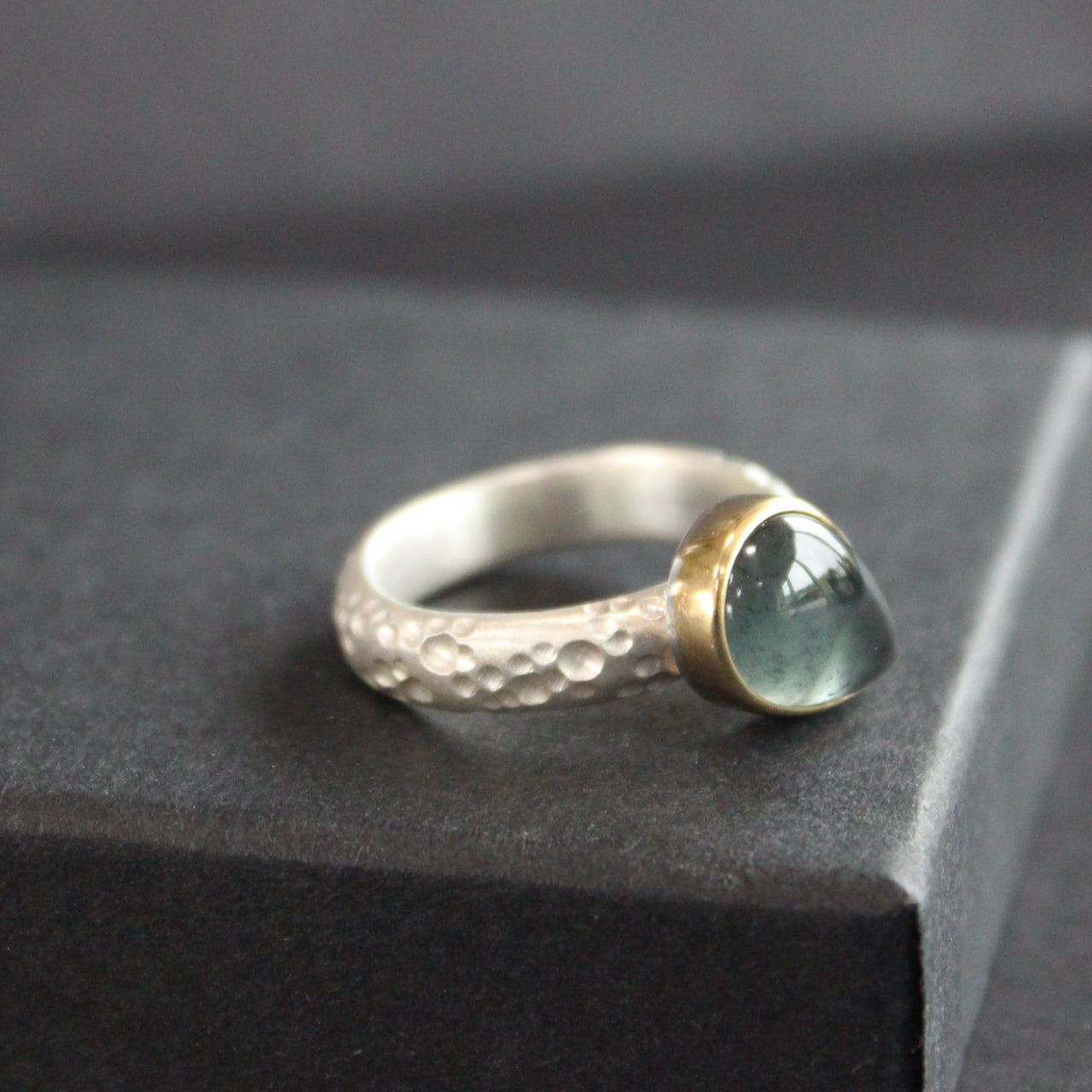 Carin Lindberg jewellery designer silver ring with teardrop shaped blue grey stone in gold setting 