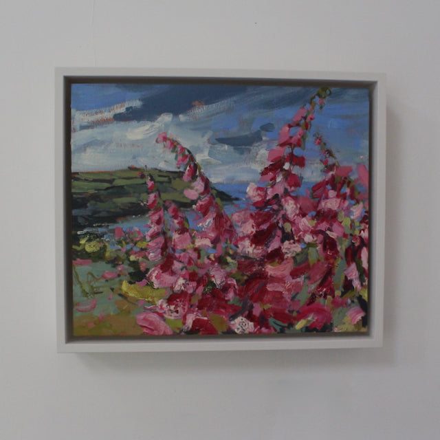 a framed oil painting of pink foxgloves with a view of Rame Head headland in the background by Cornwall artist Jill Hudson