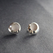 a pair of silver earrings with a textured centre by beverly bartlett, jewellery designer.