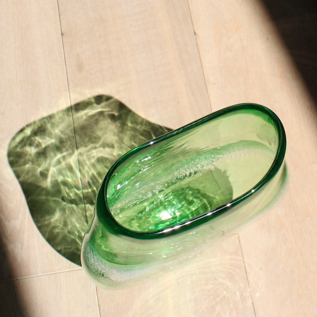 green glass vessel with centre detail by Benjamin Lintell  photographed in sunlight from above.