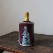 blue and red ceramic bottle with a yellow neck by John Pollex 