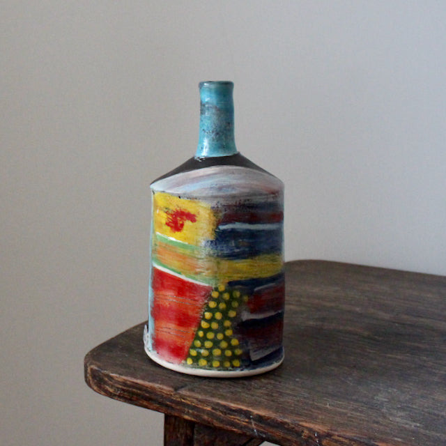multi-coloured ceramic bottle with a blue neck by John Pollex