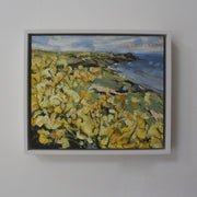 framed Jill Hudson painting of Rame Head with yellow flowers in the foreground.