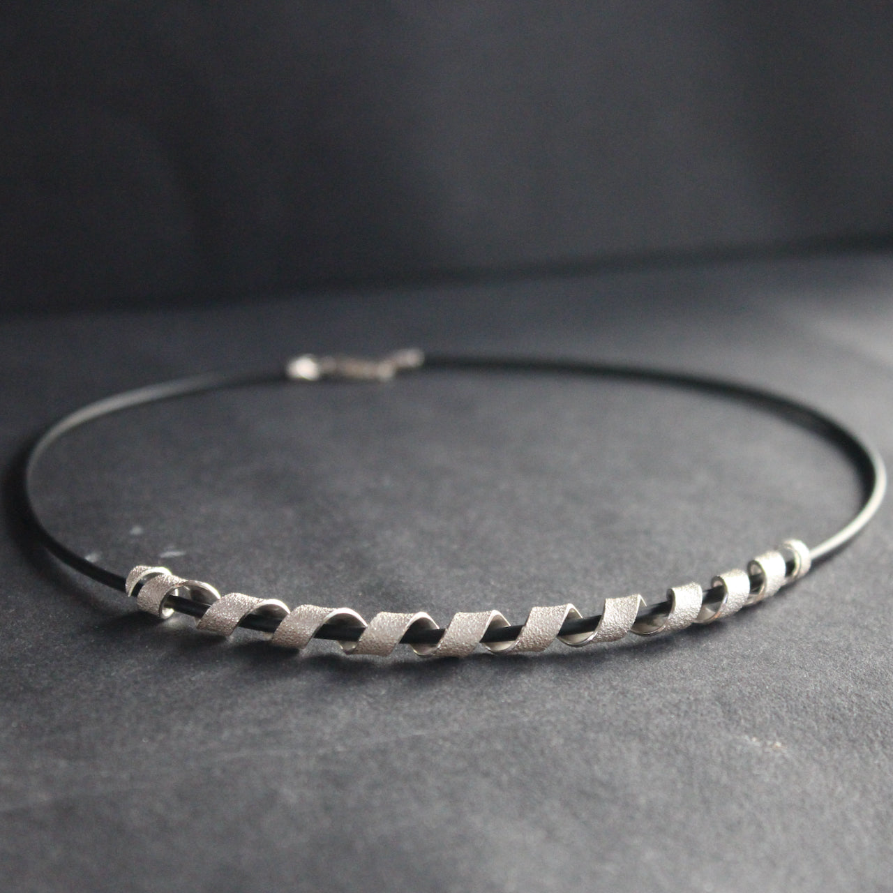 silver helix twisted necklace on black leather band by Beverly Bartlett