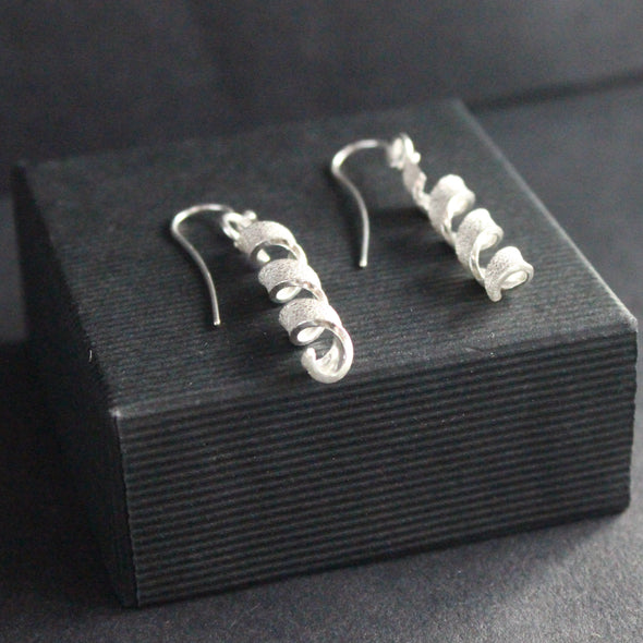 a pair of silver helix twisted earrings by Beverly Bartlett