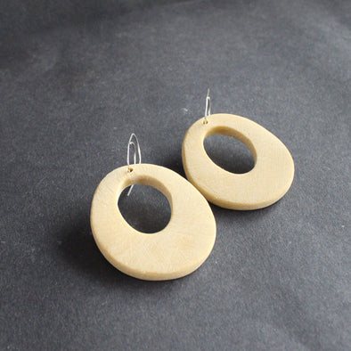 oval shaped pale yellow earrings with hole in the middle  by jewellery designer Clare Lloyd 