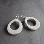 oval shaped pale grey earrings with hole in the middle  by jewellery designer Clare Lloyd 