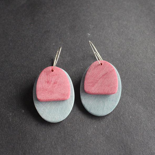 a pair of oval shaped earrings in pale blue and pink by jewellery designer Clare Lloyd 