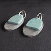 a pair of oval shaped earrings in grey and green by  Clare Lloyd. 