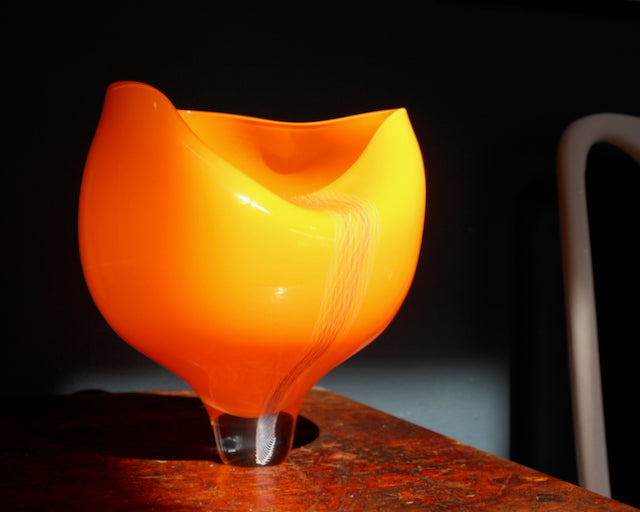 orange coloured glass vessel with line detail to the front made by UK glass artist Benjamin Lintell.
