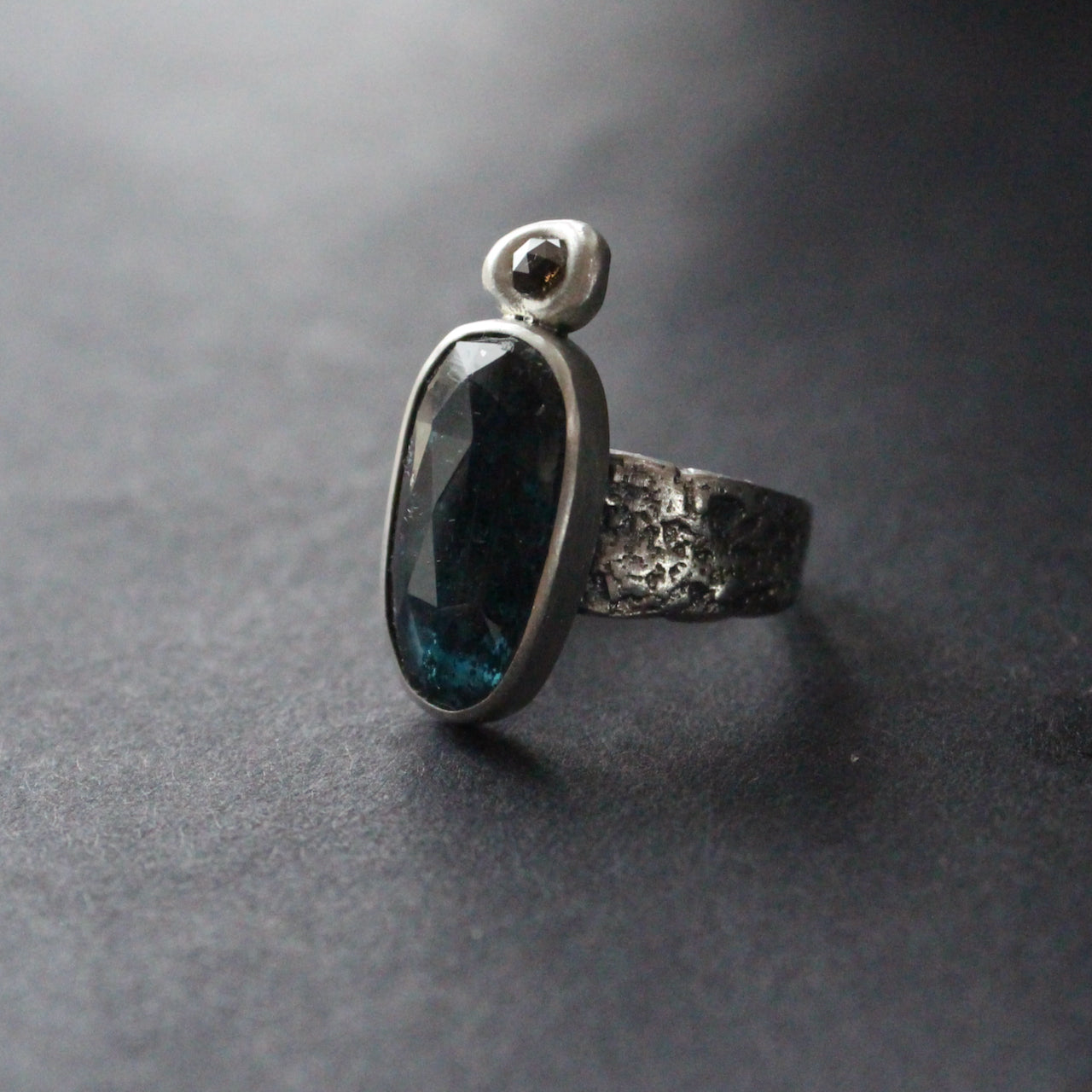 textured silver  ring with a large dark blue green stone and smaller brown diamond by Cornwall jeweller Carin Lindberg