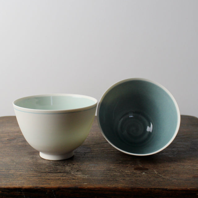 small white porcelain bowls one with pale turquoise and one with mid blue interior  by Kathryn Sherriff of By the Line Pottery