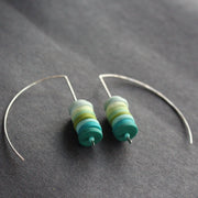 earrings made of small discs on top of each other in shades of blues and green by jewellery designer Clare Lloyd 
