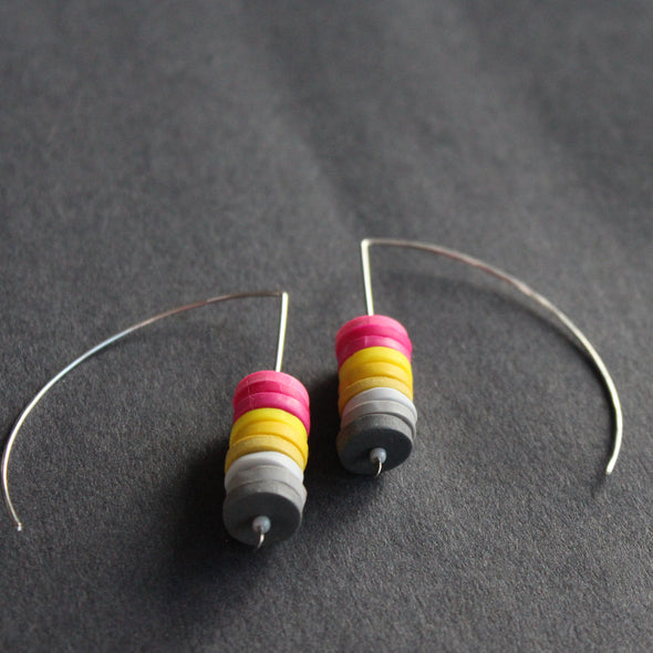earrings made of small discs on top of each other in pink, yellow and grey by jewellery designer Clare Lloyd 