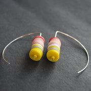 pair of earrings made of small discs on top of each other in yellow and shades of pink by UK jeweller Clare Lloyd 
