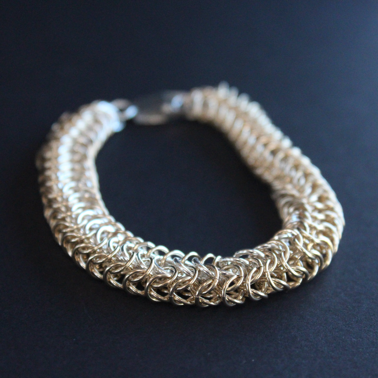 chainmail tube  bracelet in gold and silver  made by jewellery designer Corrinne Eira Evans