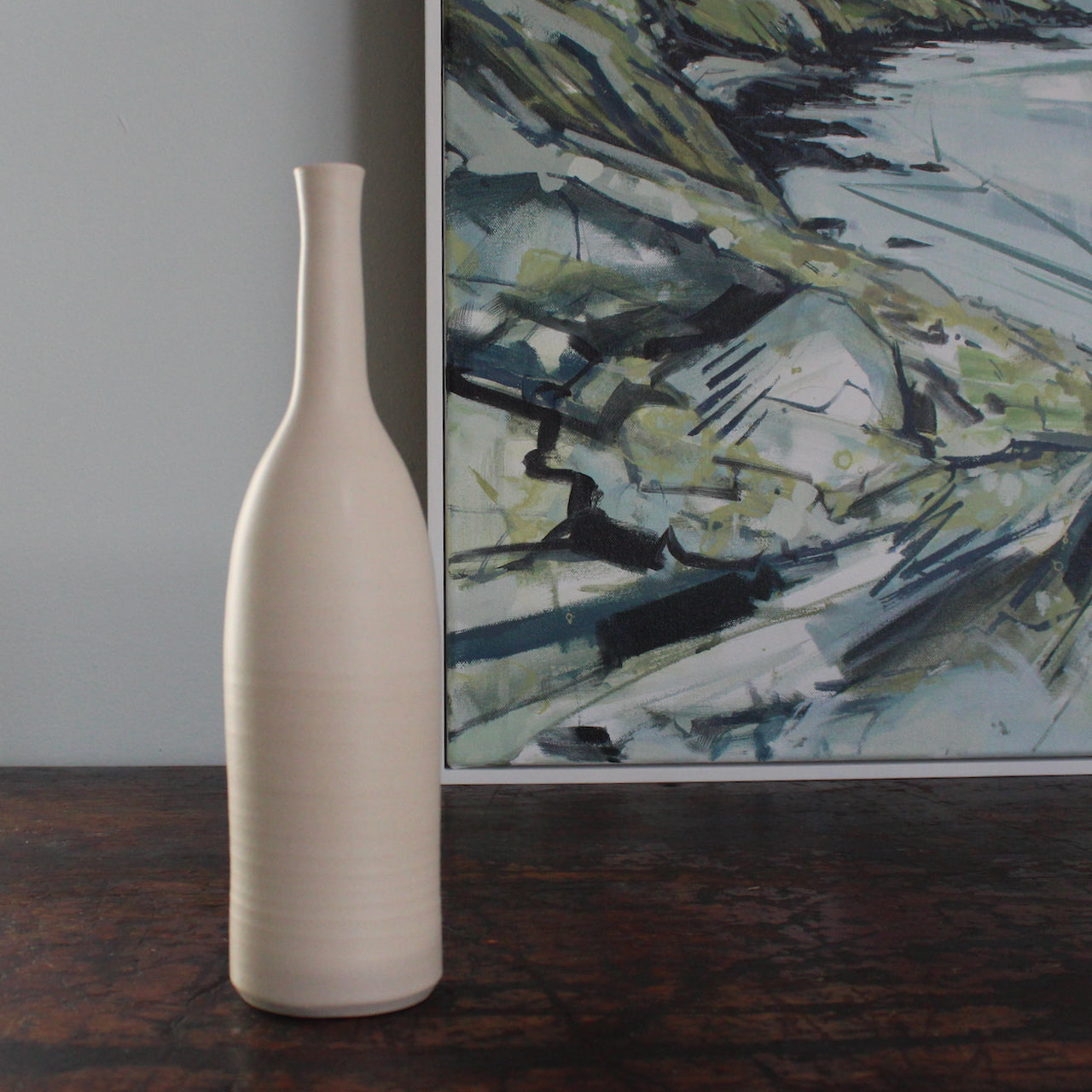 ivory coloured ceramic bottle by uk ceramic artist Lucy Burley next to corner of  landscape painting by Cornwall artist Imogen Bone