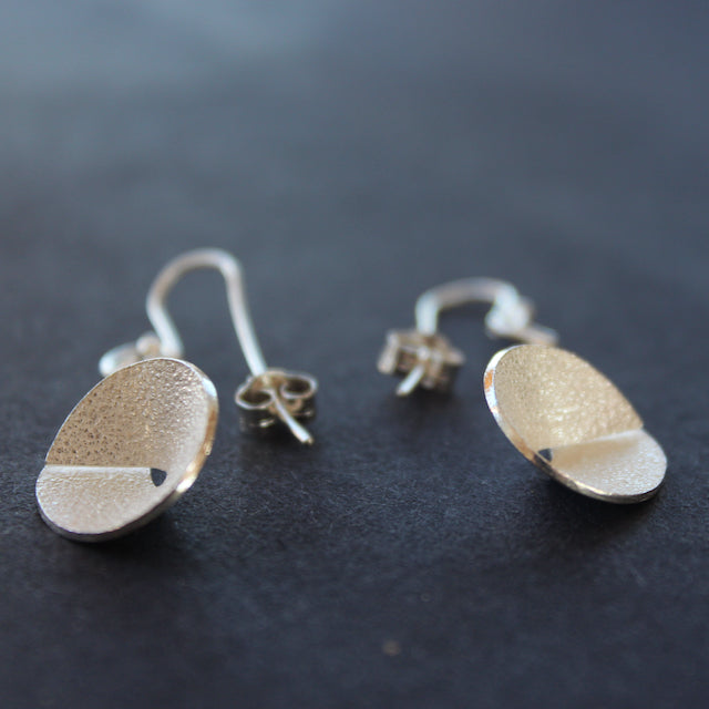 Textured silver curved and circular earrings by Beverly Bartlett.