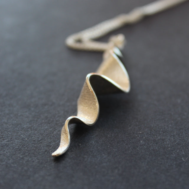 A textured silver pendant