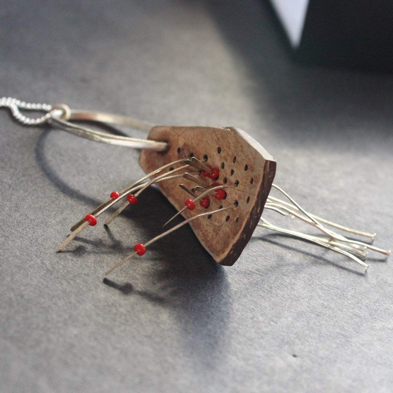 necklace of found objects wood pierced by metal strands by UK jeweller Lizzie Weir of Anatole Design