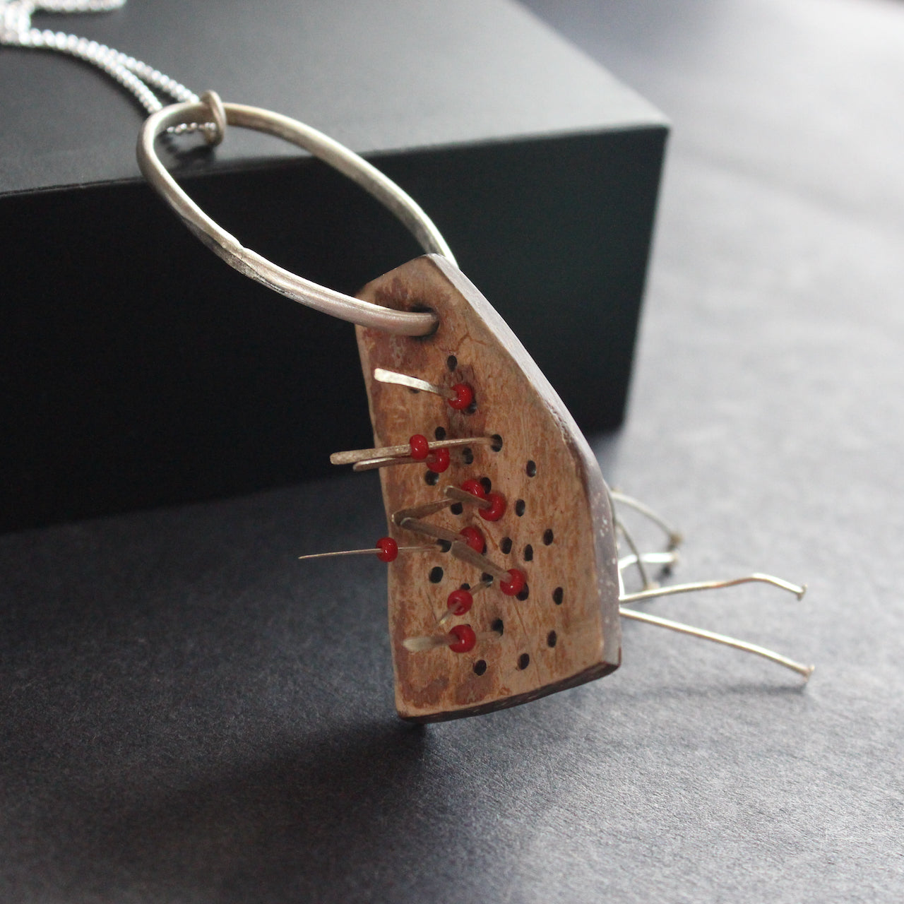 a necklace of found objects wood pierced by metal strands by UK jeweller Lizzie Weir of Anatole Design