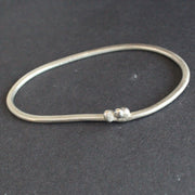 a silver bangle by UK jeweller Lizzie Weir of Anatole Design