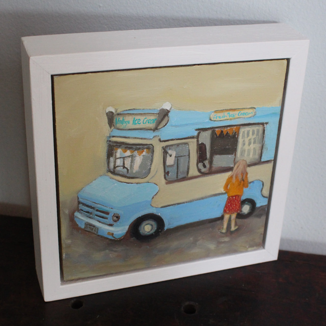framed painting by artist Siobhan Purdy of an ice cream van and a young girl with blonde hair standing at the hatch .