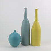 three ceramic bottles in blue, yellow and turquoise made by UK ceramic artist Lucy Burley.