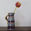 ceramic jug in blue and red glaze with a tulip in it by UK potter John Pollex