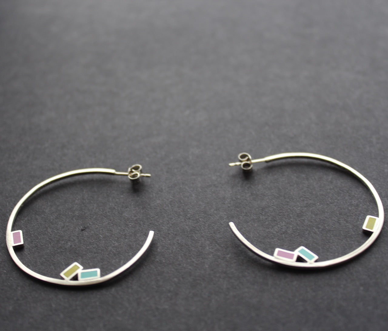 Abstract large rigid hoop earrings with small coloured squares by Clare Lloyd